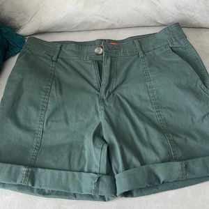 Side pockets green shorts with cuffs. Button and zipper closure.